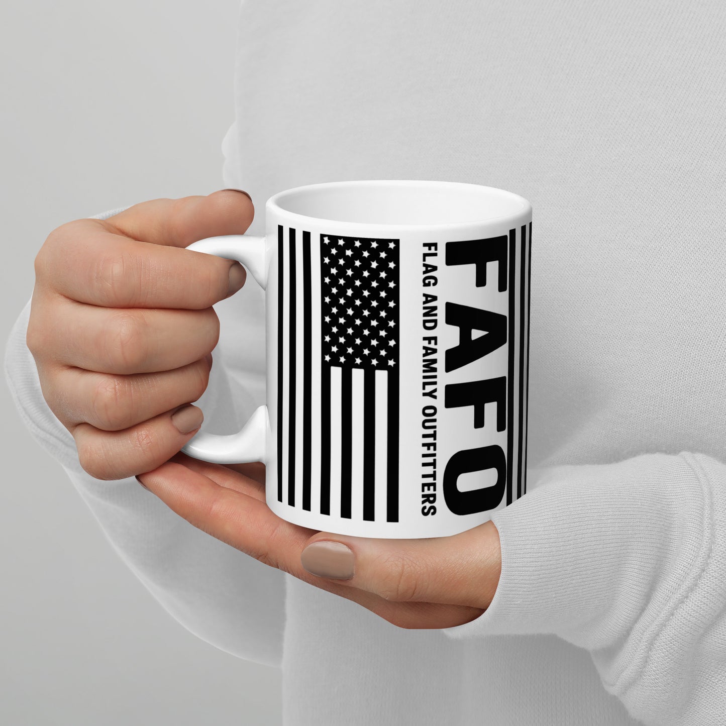 Person holding FAFO Flag Mug showing American flag and FAFO branding — fafo gear flag and family outfitters